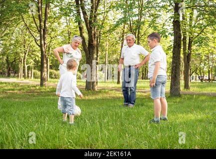 Grands-parents avec ses petits-enfants adorables jouant au football Banque D'Images