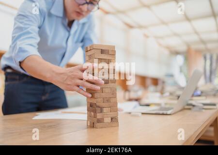 Résumé les hommes d'affaires échouent danger tour bloc construction de jeu protéger plan et le contrôle de projet. Banque D'Images