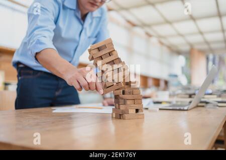 Résumé les hommes d'affaires échouent danger tour bloc construction de jeu protéger plan et le contrôle de projet. Banque D'Images