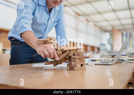Résumé les hommes d'affaires échouent danger tour bloc construction de jeu protéger plan et le contrôle de projet. Banque D'Images