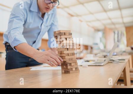 Résumé les hommes d'affaires échouent danger tour bloc construction de jeu protéger plan et le contrôle de projet. Banque D'Images
