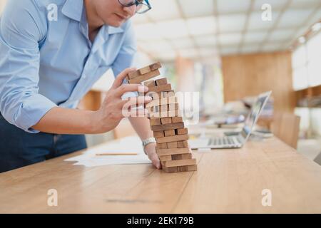 Résumé les hommes d'affaires échouent danger tour bloc construction de jeu protéger plan et le contrôle de projet. Banque D'Images