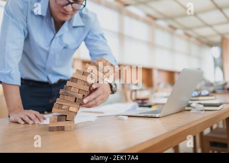 Résumé les hommes d'affaires échouent danger tour bloc construction de jeu protéger plan et le contrôle de projet. Banque D'Images