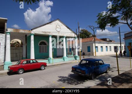 HOLGUIN, CUBA - 18 FÉVRIER; 2020 voiture rouge et voiture classique bleue garées à l'extérieur de l'immeuble de la vieille ville Banque D'Images