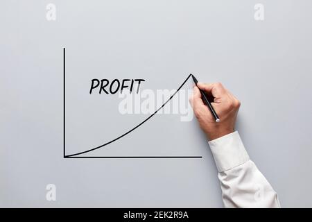 Main de sexe masculin représentant un tableau des bénéfices sur fond gris. Augmentation des bénéfices dans le concept d'entreprise Banque D'Images