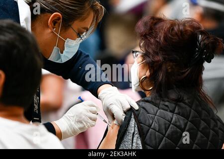 (210223) -- ECATEPEC, 23 février 2021 (Xinhua) -- UN travailleur médical inocule un citoyen avec un vaccin COVID-19 mis au point par la société pharmaceutique chinoise Sinovac sur un site de vaccination à Ecatepec, Mexique, 22 février 2021. Les autorités sanitaires mexicaines ont commencé lundi à vacciner les adultes âgés avec un vaccin COVID-19 mis au point par la société pharmaceutique chinoise Sinovac, après l'arrivée d'une cargaison de doses samedi. Le gouvernement mexicain a désigné la première expédition du vaccin Sinovac pour arriver à Ecatepec, une ville du centre de l'État du Mexique qui se trouve à la périphérie de la capitale Mexico. Banque D'Images