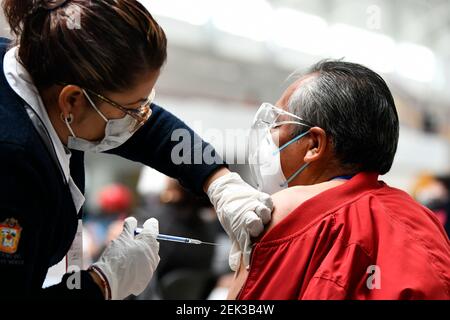 (210223) -- ECATEPEC, 23 février 2021 (Xinhua) -- UN travailleur médical inocule un citoyen avec un vaccin COVID-19 mis au point par la société pharmaceutique chinoise Sinovac sur un site de vaccination à Ecatepec, Mexique, 22 février 2021. Les autorités sanitaires mexicaines ont commencé lundi à vacciner les adultes âgés avec un vaccin COVID-19 mis au point par la société pharmaceutique chinoise Sinovac, après l'arrivée d'une cargaison de doses samedi. Le gouvernement mexicain a désigné la première expédition du vaccin Sinovac pour arriver à Ecatepec, une ville du centre de l'État du Mexique qui se trouve à la périphérie de la capitale Mexico. Banque D'Images