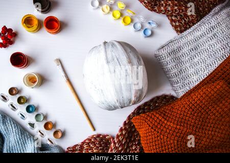 BRICOLAGE. Faites-le vous-même. Une femme peint des décorations d'action de grâce sur la citrouille d'orange pour Halloween. Récolte d'automne. Chandail maison confortable. Pinceau Banque D'Images