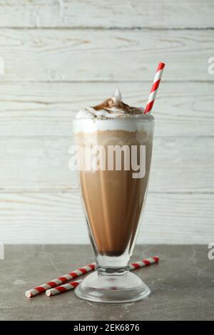 Un verre de milk-shake au chocolat et des pailles sur une table grise Banque D'Images