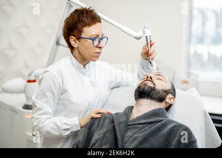 Cosmétologue faisant la procédure de facélifting laser dans la clinique de beauté Banque D'Images