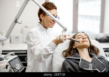 Cosmétologue faisant la procédure de facélifting laser dans la clinique de beauté Banque D'Images