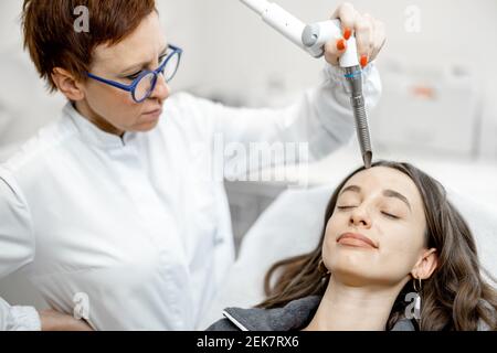 Cosmétologue faisant la procédure de facélifting laser dans la clinique de beauté Banque D'Images