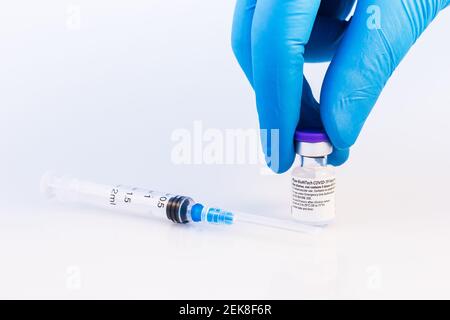 Brasov, Roumanie - 21 février 2021 : médecin ou scientifique détenant le vaccin Pfizer-BioNTech Covid-19 sur fond blanc. Banque D'Images