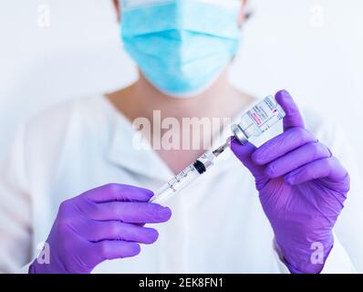 Brasov, Roumanie - 21 février 2021 : médecin utilisant le vaccin Moderna Covid-19 sur fond blanc. Banque D'Images
