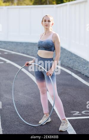 Belle jeune femme caucasienne en forme physique vêtements d'entraînement dans un stade. Banque D'Images