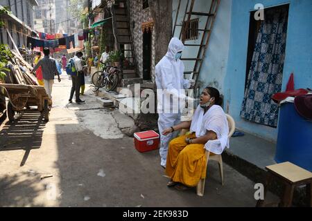 Un professionnel de la santé portant un équipement de protection individuelle (EPI) prélève un échantillon d'écouvillon auprès d'une femme résidant dans une colonie de taudis à Dharavi.les cas de virus Corona ont augmenté dans l'État du Maharashtra après le confinement. Il a été conseillé aux gens de ne pas se rassembler en grand nombre dans les lieux publics, de maintenir une distance sociale, de porter un masque et de se désinfecter les mains régulièrement. Banque D'Images