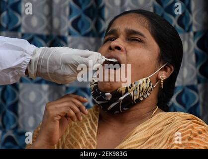 Un professionnel de la santé recueille un échantillon d'écouvillonnage auprès d'une femme résidant dans une colonie de taudis à Dharavi.les cas de virus Corona ont augmenté dans l'état de Maharashtra après le confinement. Il a été conseillé aux gens de ne pas se rassembler en grand nombre dans les lieux publics, de maintenir une distance sociale, de porter un masque et de se désinfecter les mains régulièrement. Banque D'Images