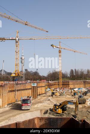 Munich, Allemagne. 23 février 2021. Les travailleurs de la construction travaillent avec des véhicules sur le chantier du jardin SAP, le nouveau terrain de hockey sur glace et de basket-ball, tandis que la Tour olympique et le stade olympique sont visibles en arrière-plan. Financé par Red Bull, le hall multifonctionnel, qui sera appelé SAP Garden, devrait être achevé en 2022. Credit: Matthias balk/dpa/Alay Live News Banque D'Images