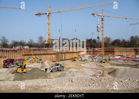 Munich, Allemagne. 23 février 2021. Les travailleurs de la construction travaillent avec des véhicules sur le chantier du jardin SAP, le nouveau terrain de hockey sur glace et de basket-ball, tandis que la Tour olympique et le stade olympique sont visibles en arrière-plan. Financé par Red Bull, le hall multifonctionnel, qui sera appelé SAP Garden, devrait être achevé en 2022. Credit: Matthias balk/dpa/Alay Live News Banque D'Images