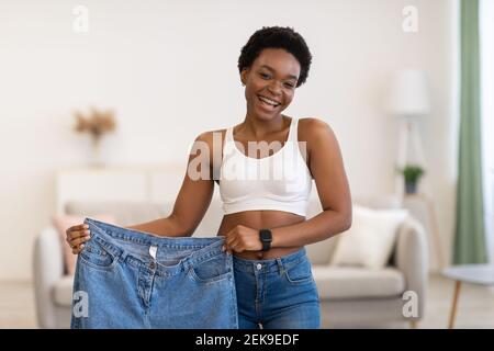 African American Lady tenant de grands jeans après avoir réussi Sliming à l'intérieur Banque D'Images