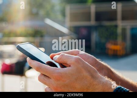 Gros plan de la main d'homme d'affaires à l'extérieur avec un téléphone mobile Banque D'Images