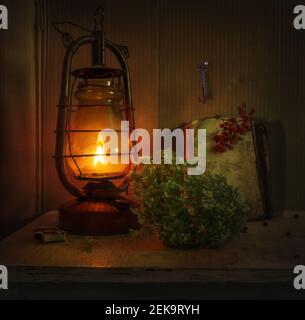 Une lampe au kérosène illumine une fleur d'hortensia, une clé sur le mur, et un livre avec une branche de rowan. Vintage. Rétro. Banque D'Images