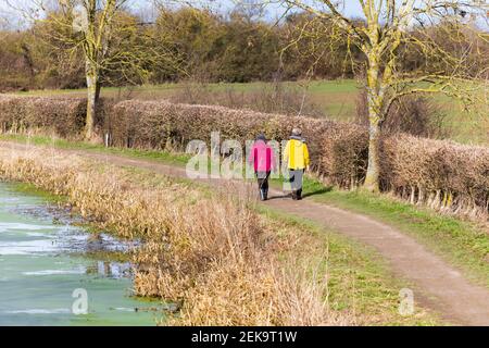 Deux femmes adultes plus âgées avec des bâtons de marche, faisant une promenade d'exercice le long d'un sentier de remorquage de canal pendant la pandémie Covid 19. Grantham, Lincolnshire, Angleterre Banque D'Images
