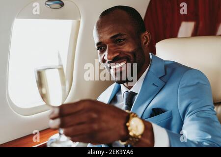Homme d'affaires souriant avec du champagne à l'air Banque D'Images