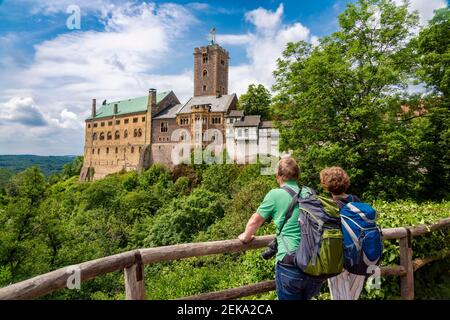 Les touristes qui regardent le château de Wartburg tout en se tenant à côté de la rampe en bois à Eisenach, Allemagne Banque D'Images
