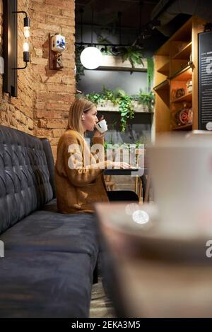 Belle femme ayant une tasse de café à la cafétéria Banque D'Images