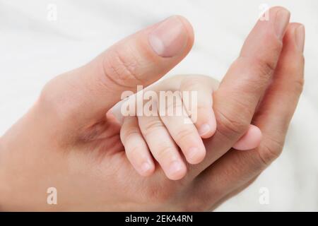 Femme tenant sa main de bébé Banque D'Images