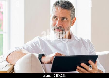 Homme d'affaires avec une tablette numérique qui regarde à la maison Banque D'Images