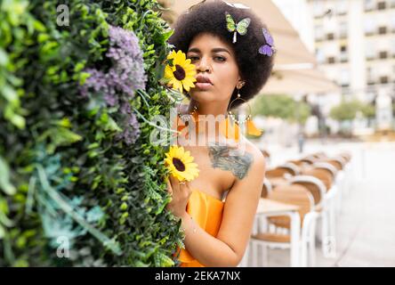 Hipster femelle se cachant derrière la plante sur le sentier Banque D'Images