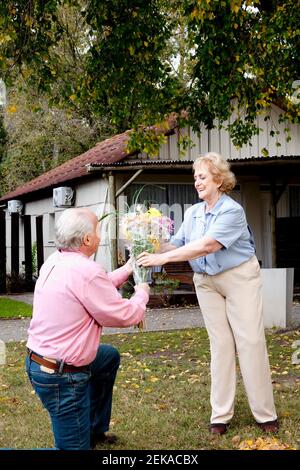 Homme donnant un bouquet de fleurs à sa femme Banque D'Images