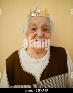 Portrait en gros plan d'une femme âgée souriante portant une couronne en papier Banque D'Images