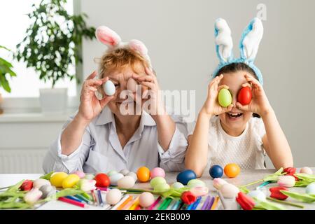 Concept de Pâques. La grand-mère avec sa petite-fille tient des œufs de Pâques à la maison Banque D'Images