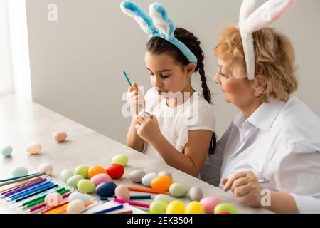 Concept de Pâques. La grand-mère avec sa petite-fille tient des œufs de Pâques à la maison Banque D'Images