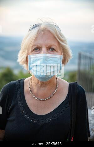 Femme âgée portant un masque facial de protection en regardant à l'extérieur Pendant COVID-19 Banque D'Images