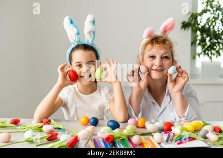 Concept de Pâques. La grand-mère avec sa petite-fille tient des œufs de Pâques à la maison Banque D'Images