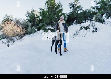 Jeune homme et chien randonnée sur la neige en hiver Banque D'Images