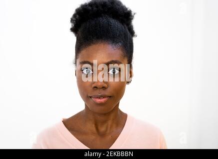 Surpris femme regardant en se tenant sur fond blanc Banque D'Images