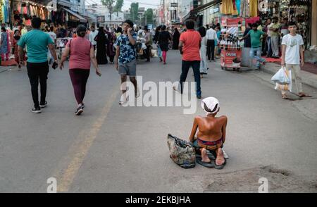 Homme pauvre chroniquement handicapé à la recherche d'almes le long de la rue dans la place occupée de marché à Delhi, Uttar Prades Banque D'Images