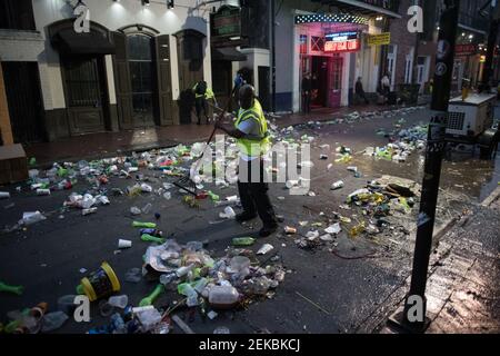 Les travailleurs de l'assainissement s'attaquent à la tâche redoutable de nettoyer la rue Bourbon, jonchée de déchets, à la suite des célébrations de mardi gras à la Nouvelle-Orléans. Banque D'Images