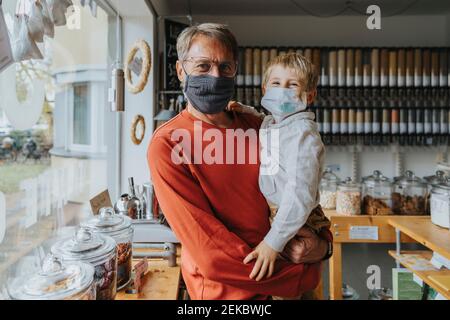 Père et fils se tenant dans un magasin de déchets zéro pendant la COVID-19 Banque D'Images