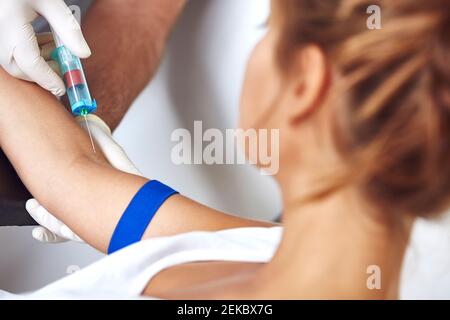 Mains du médecin recueillant le sang de la patiente à l'hôpital Banque D'Images