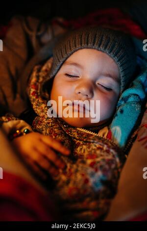 Bébé fille portant un chapeau en tricot dormant pendant l'hiver Banque D'Images