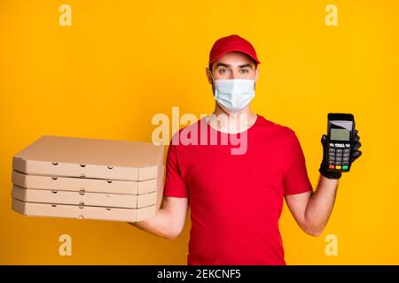 Photo portrait d'un messager tenant des boîtes à pizza, port de la banque masque facial pendant l'épidémie isolé sur fond jaune vif Banque D'Images