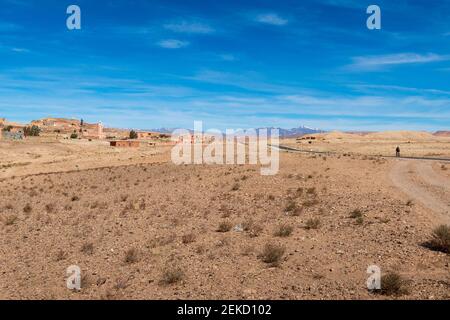 Draa-Tafilalet, Maroc - 14 avril 2016 : petit village traditionnel le long d'une route dans la région de Draa-Tafilalet, avec les montagnes de l'Atlas à l'arrière Banque D'Images