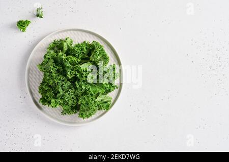 Bol de chou vert frais haché sur fond de pierre gris clair, vue de dessus. Ingrédient pour préparer une salade saine. Concept propre de manger, de détox ou de régime. M Banque D'Images