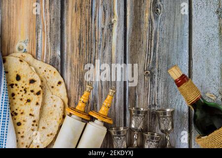 Célébration de la Pâque des grands symboles de vacances de la famille juive avec une assiette de séder traditionnelle de kasher matzah, un rouleau de torah et quatre tasses de vin Banque D'Images